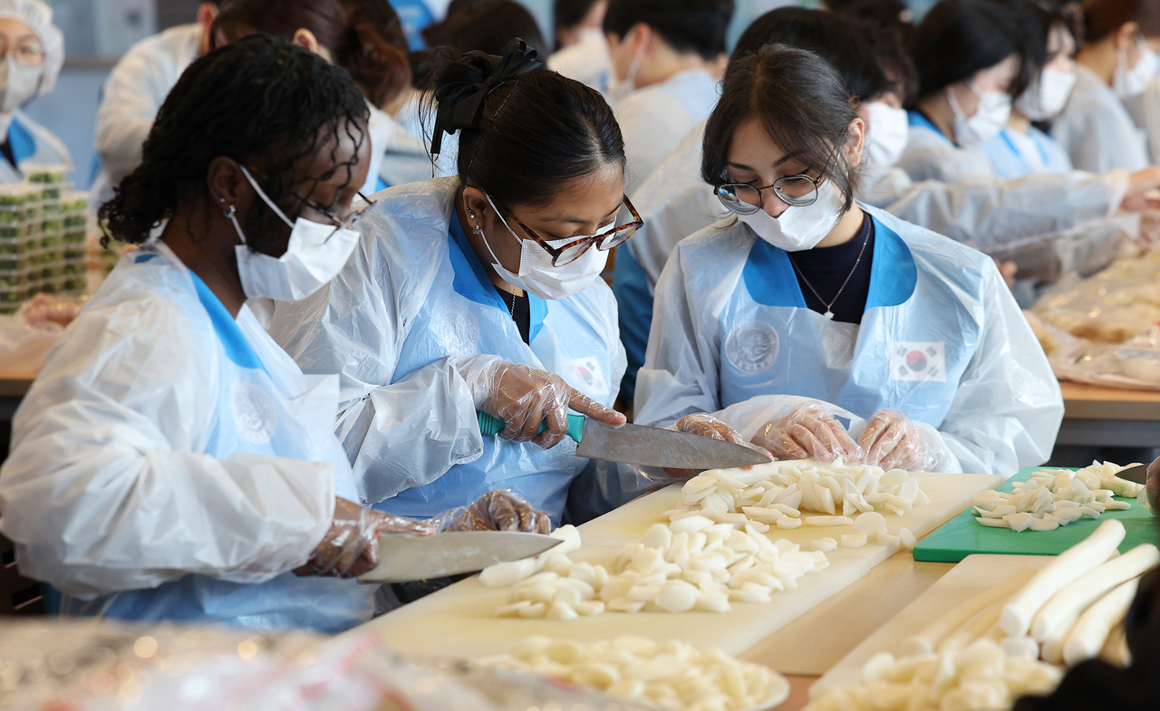 International students make tteokguk during an event at Yeongnam University in North Gyeongsang Province on Monday. (Yonhap)