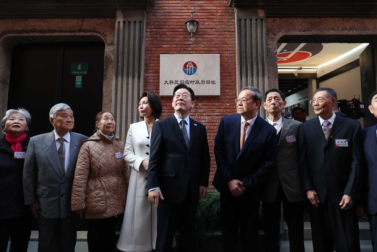 President Lee Jae Myung (center, right) and first lady Kim Hea Kyung (center, left) visit the former headquarters of South Korea’s provisional government, established in Shanghai in April 1919 during Japanese colonial rule, on Wednesday, along with descendants of independence fighters. The visit took place as part of a ceremony marking the 100th anniversary of the provisional government’s relocation to the building in 1926. (Yonhap)