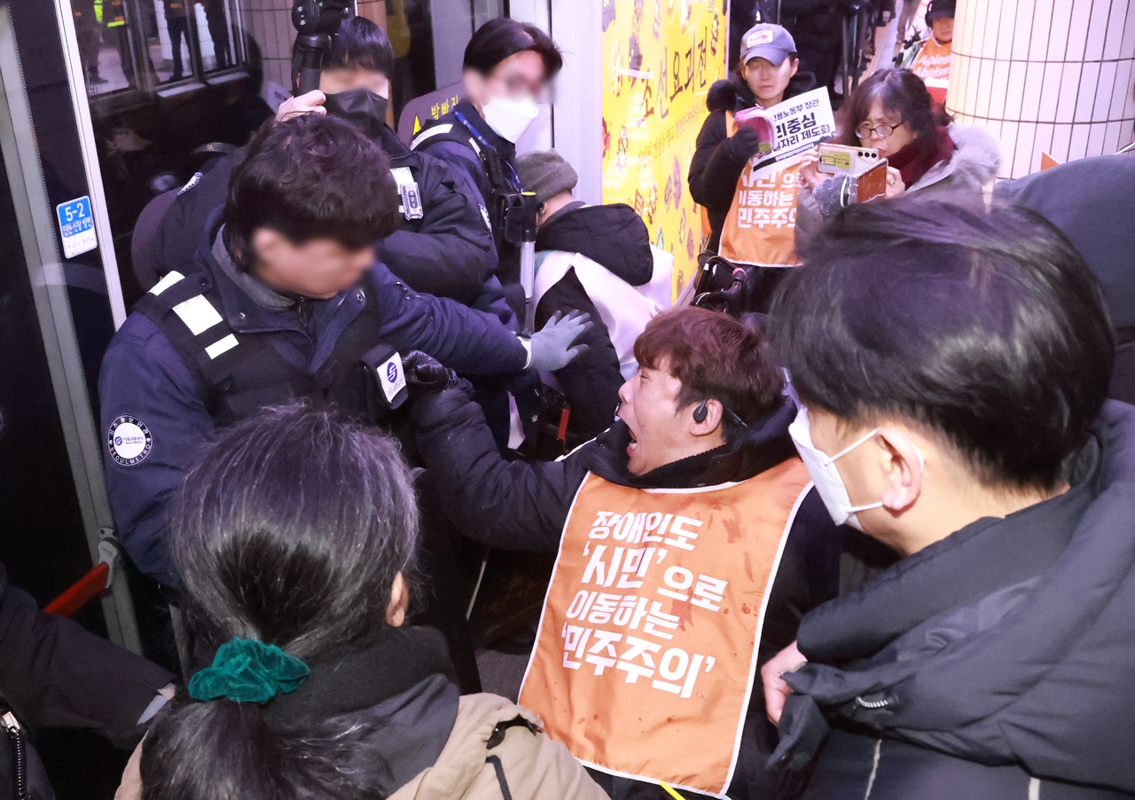 Members of Solidarity Against Disability Discrimination hold a protest to disrupt subway traffic in Seoul Metro's City Hall station at Line No. 2 on Frdiay. (Yonhap)
