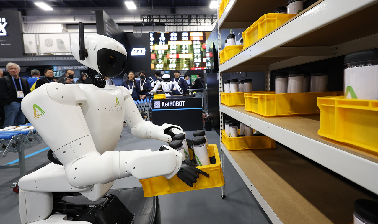 On the opening day of CES on Jan. 6, AeiROBOT’s humanoid robot Alice moves items onto a shelf at the Las Vegas Convention Center in Las Vegas. (Yonhap)