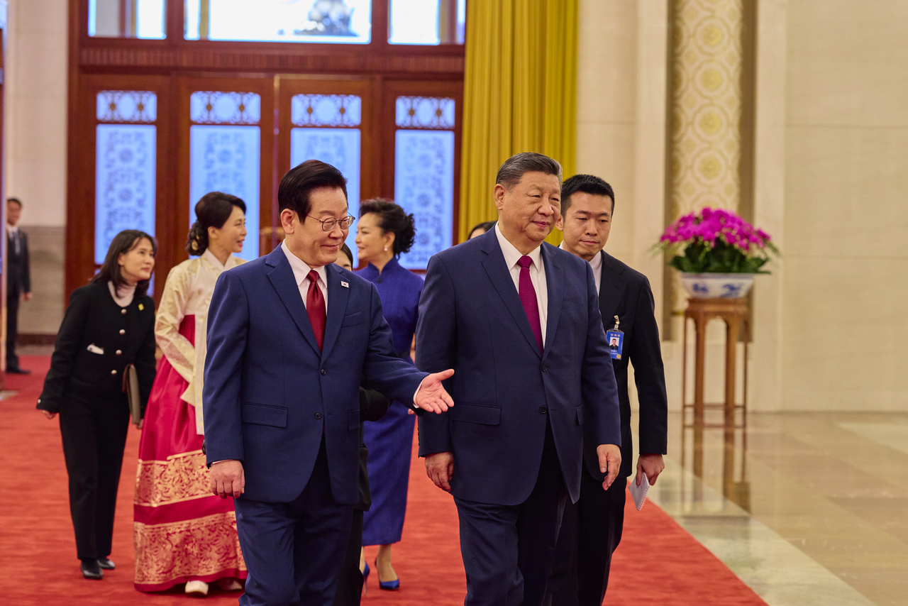 South Korean President Lee Jae Myung (left) and Chinese President Xi Jinping head to summit talks after an official welcoming ceremony at the Great Hall of the People in Beijing on Monday. (Yonhap)