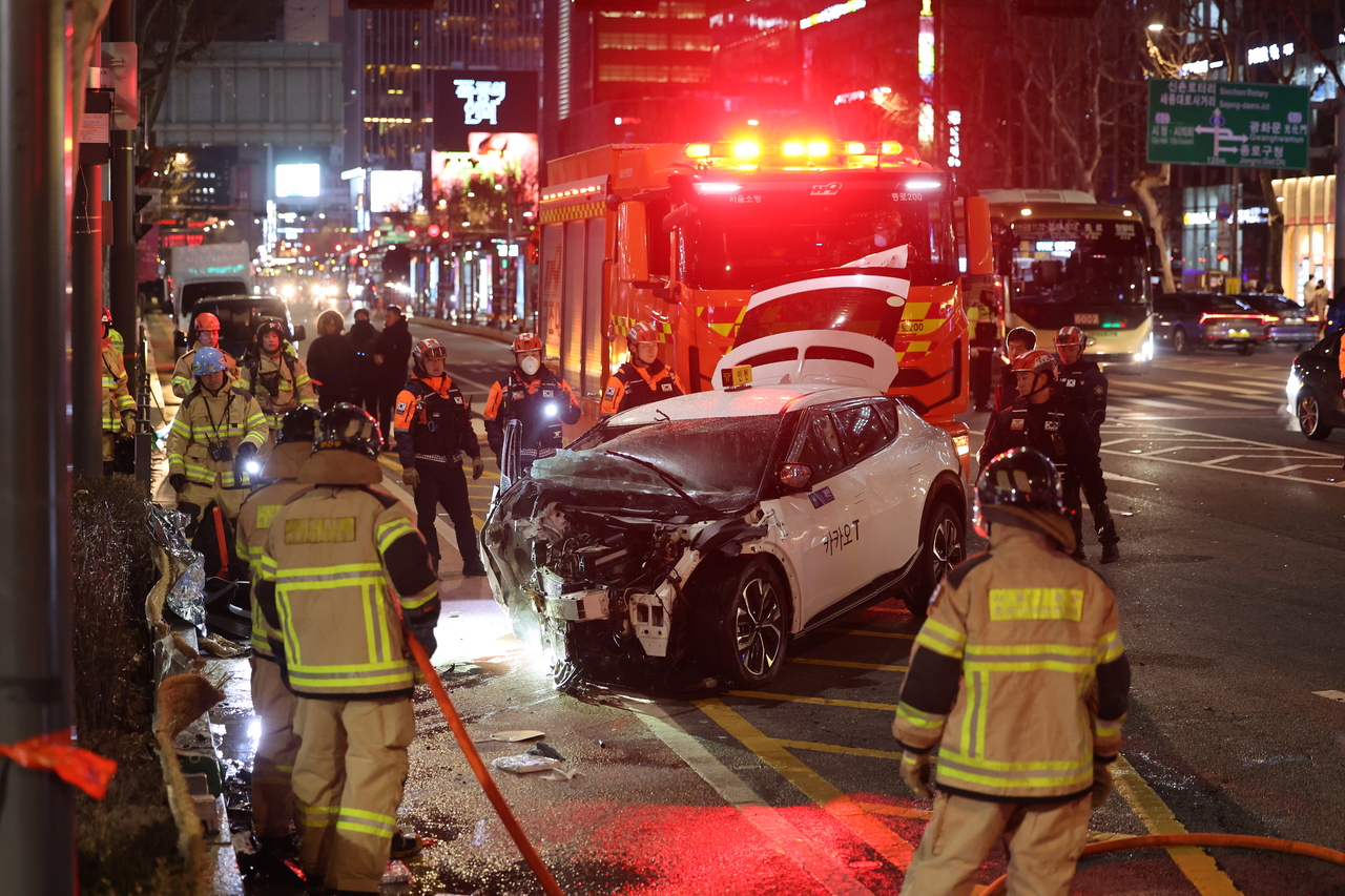 Rescue officials are seen on the site of the fatal car crash in Jongno-gu, central Seoul, on Dec. 2, which killed one and injured 15. (Yonhap)