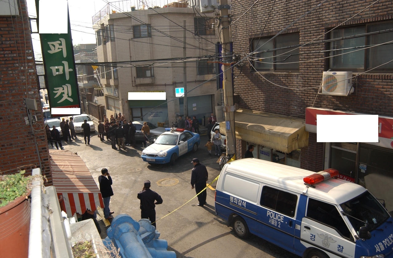 A photo released by Seoul Metropolitan Police shows the scene where a body wrapped in rice sacks was discovered on the side of the road in Seoul’s Sinjeong-dong in 2005, later identified as the first of two serial murders in the area. (Seoul Metropolitan Police)