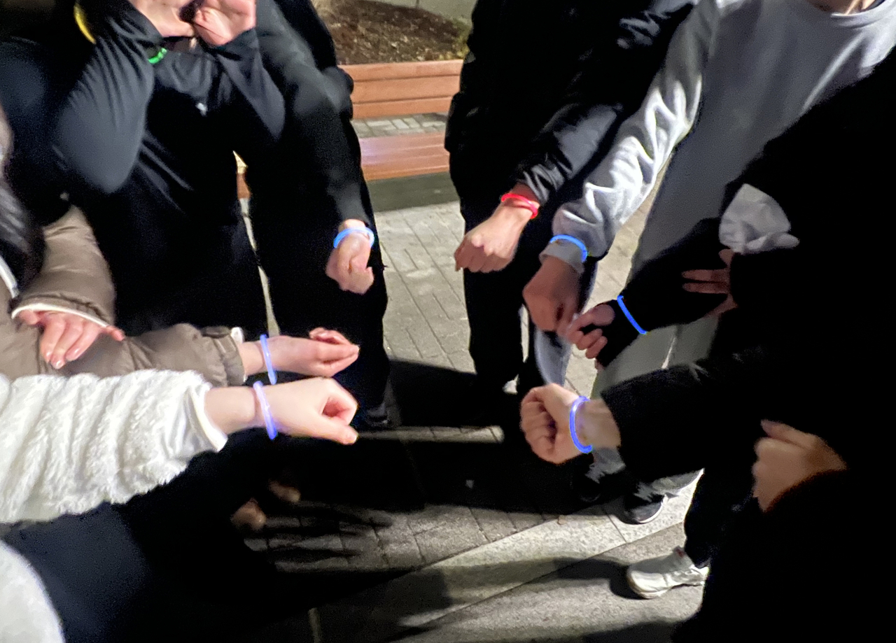 지난해 12월 24일 서울 강서구 서울식물원 잔디밭에서 열린 ‘경찰과 도둑’ 놀이에서 경찰 역할을 맡은 사람들이 형광 팔찌를 차고 있다. [연합]