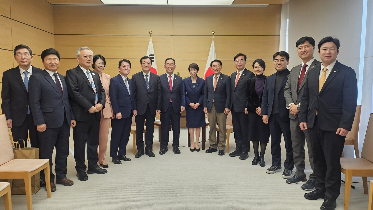Japanese Prime Minister Sanae Takaichi (seventh from right) and Korean lawmakers pose for a photo at the former's office in Tokyo on Friday. (Yonhap)