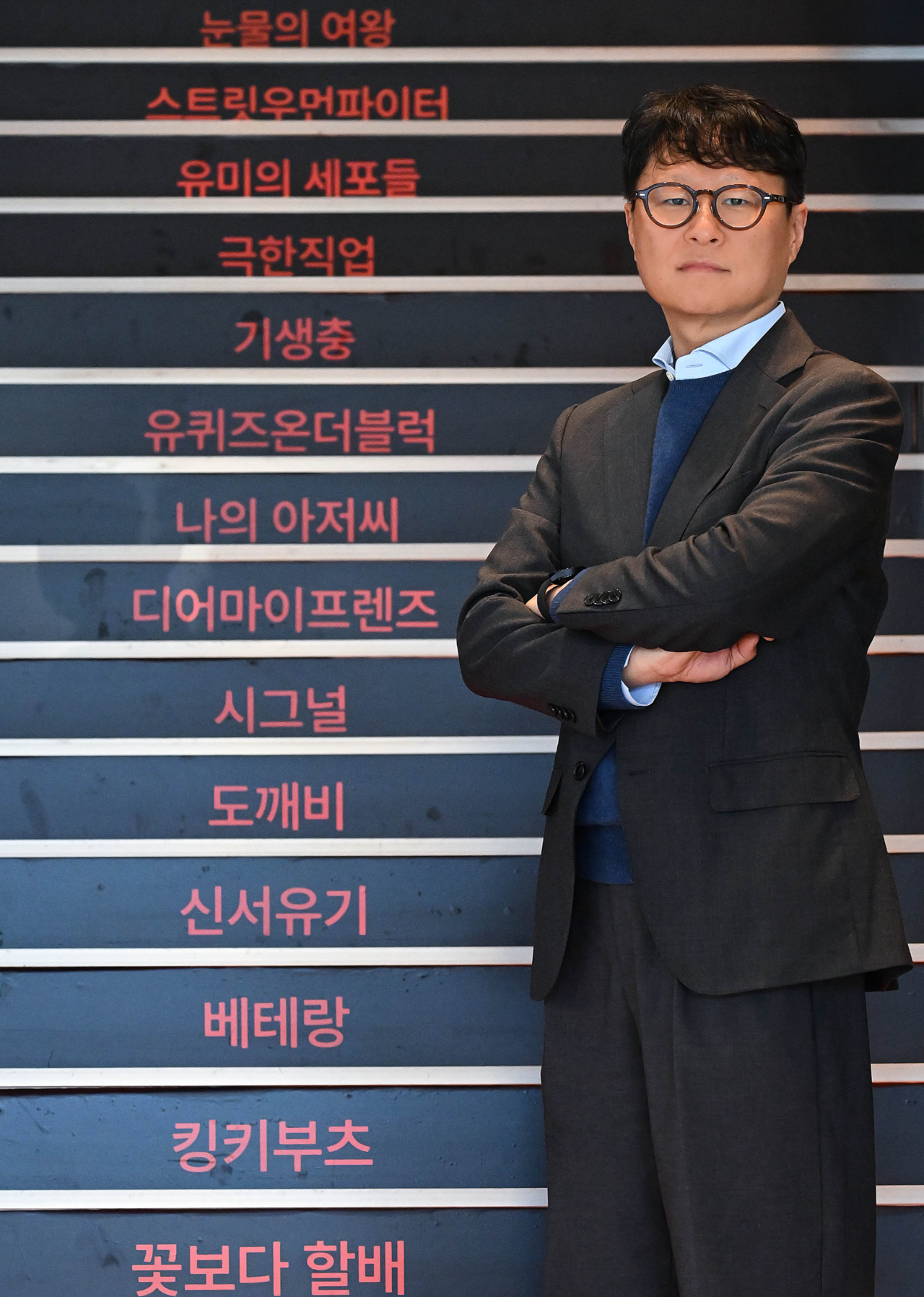 Yea Ju-yeol, head of CJ ENM's Performing Arts Division, poses in front of a staircase displaying the company’s hit projects at the CJ ENM Center in Sangam-dong, Mapo-gu, Seoul, on Dec. 3. (Lee Sang-sub/The Korea Herald)