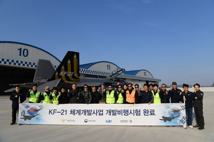 Test pilots and officials pose for a photo in front of the KF-21 prototype during a ceremony commemorating the completion of its final development flight tests on Monday in Sacheon, South Gyeongsang Province. (Defense Acquisition Program Administration)