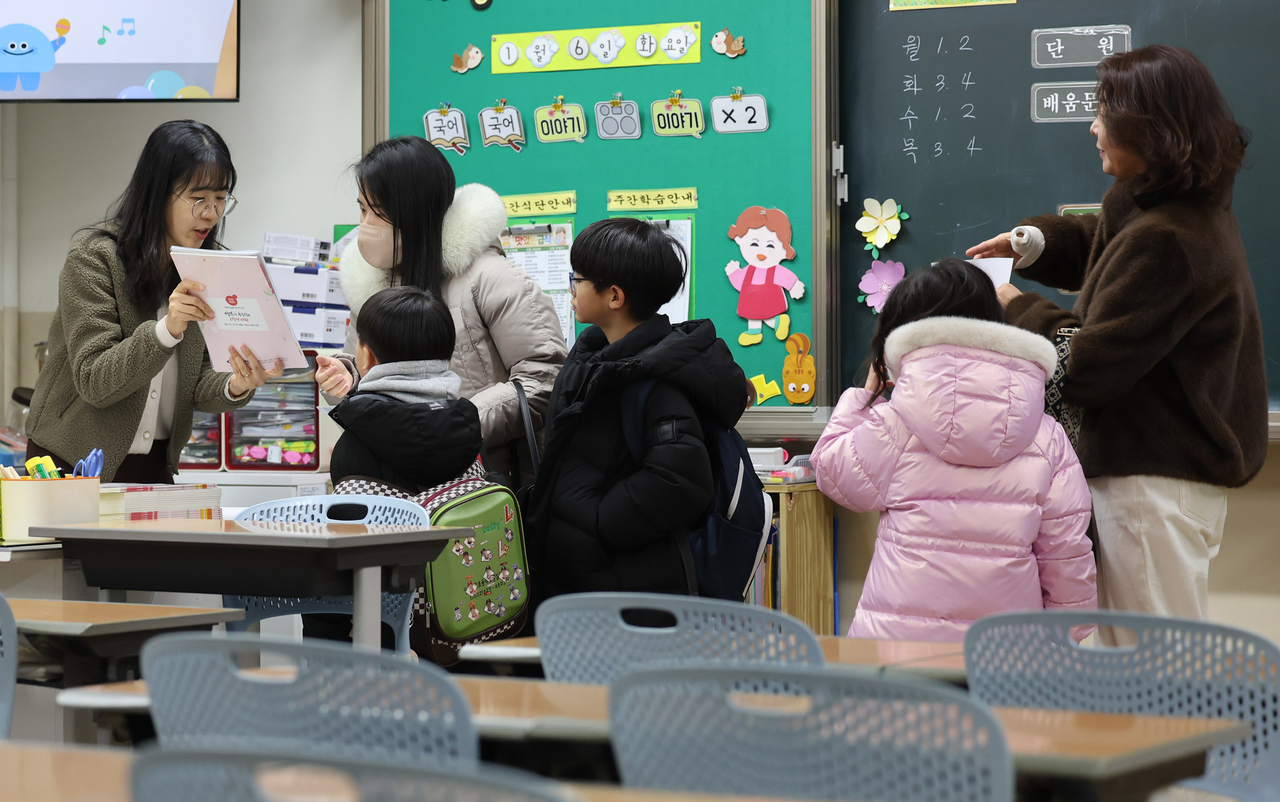 A parent of a prospective first-grade student listens to a teacher explain enrollment procedures at Jeonggak Elementary School in Namdong-gu, Incheon, on the 6th, during the preliminary enrollment day for children entering school in the 2026 academic year. (Newsis)