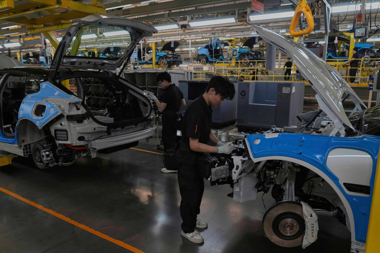 Workers assemble the Zeekr 001 EV models at the Chinese automaker Zeekr assembly plant in Ningbo, east China's Zhejiang Province, April 17.   AP-Yonhap