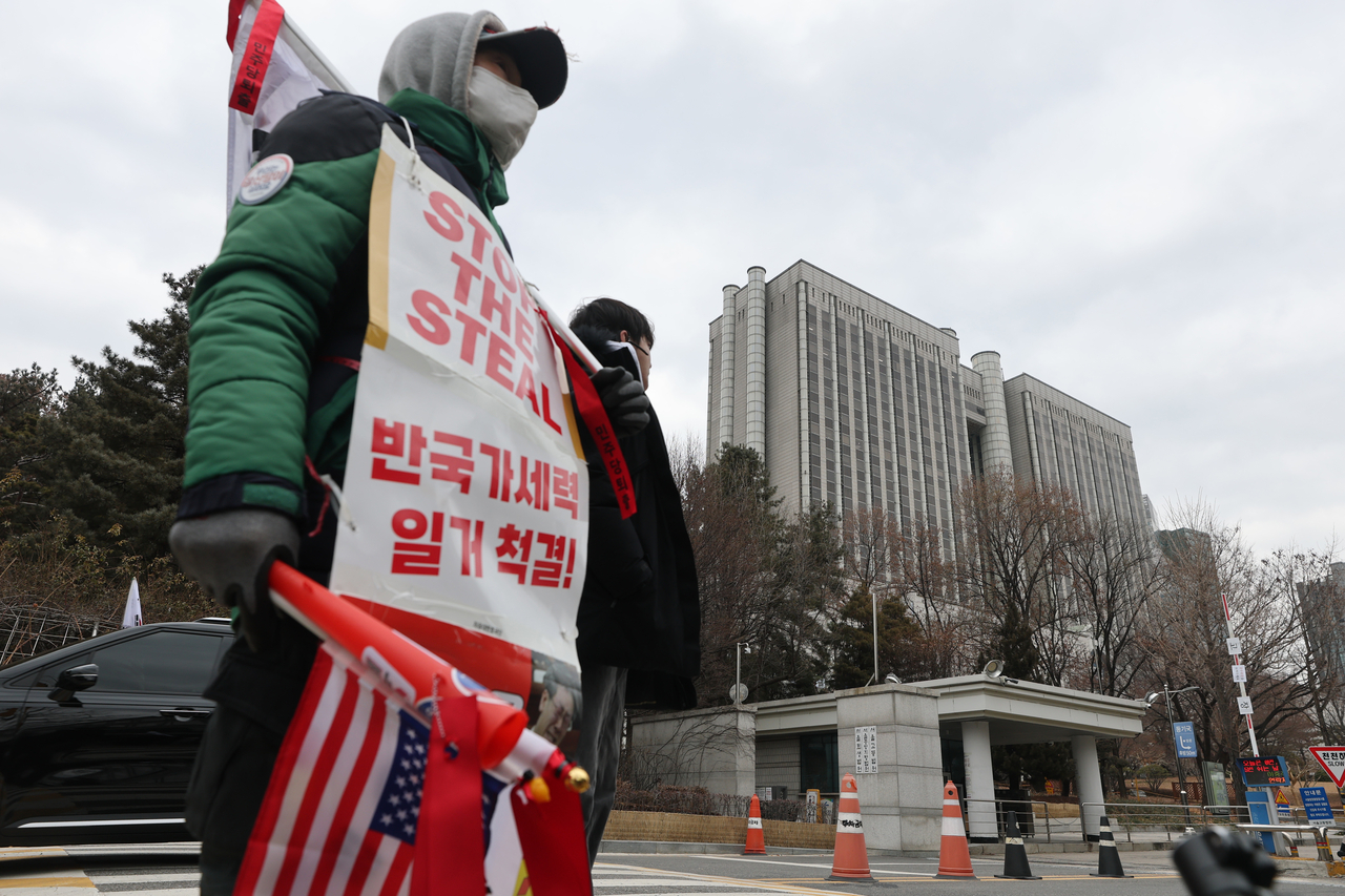 A supporter of former President Yoon Suk Yeol stages a one-person protest Friday in front of the Seoul Central District Court, ahead of what was scheduled to be the final hearing of Yoon's insurrection case. (Yonhap)