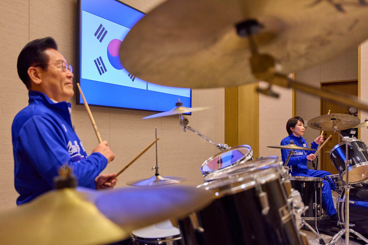 South Korean President Lee Jae Myung (left) and Japanese Prime Minister Sanae Takaichi play the drums following their joint press conference after a summit in Nara prefecture, Japan, Tuesday. (Pool Photo via Yonhap)