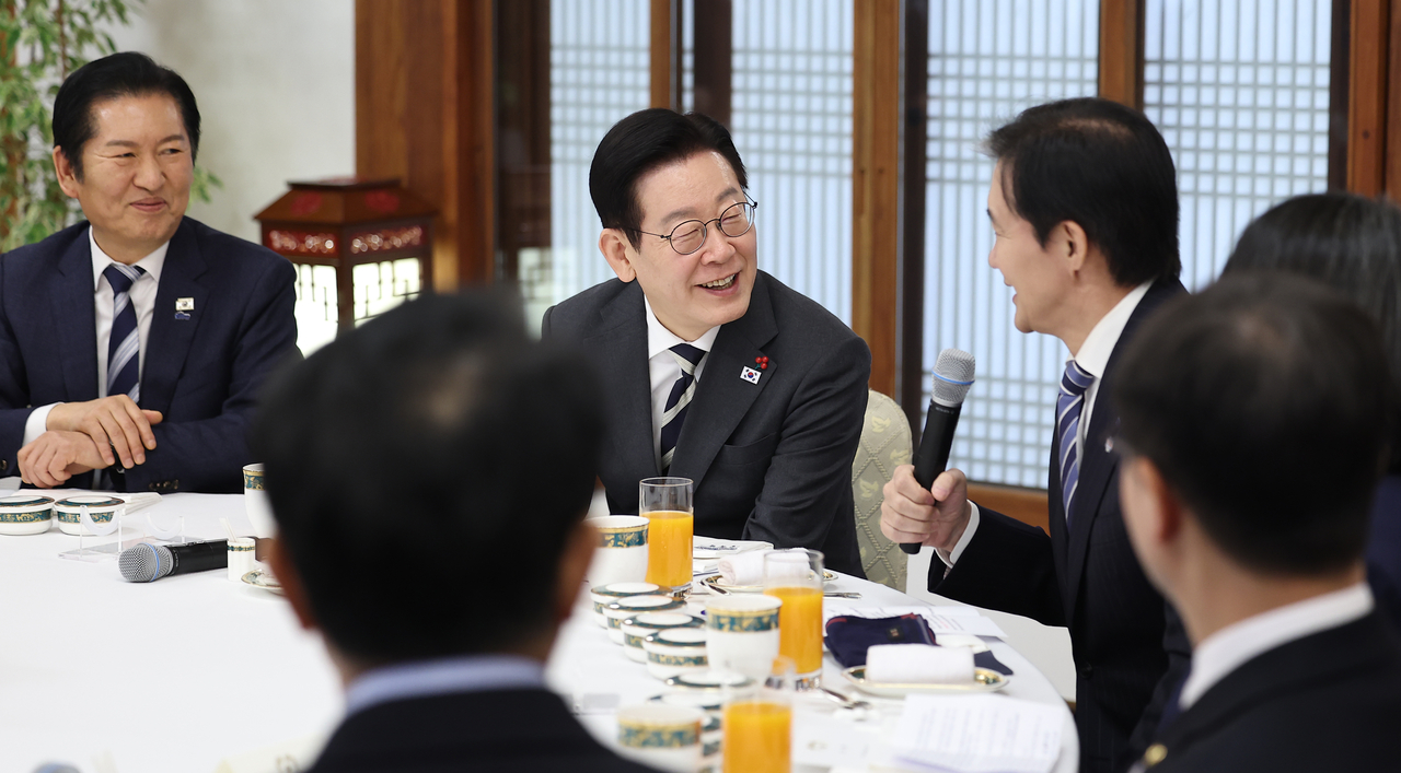 President Lee Jae Myung (center), ruling Democratic Party of Korea Chair Rep. Jung Chung-rae (left) and liberal minor Rebuilding Korea Party Chair Cho Kuk (right) attend a lunch meeting hosted by Lee at Cheong Wa Dae on Friday. (Yonhap)