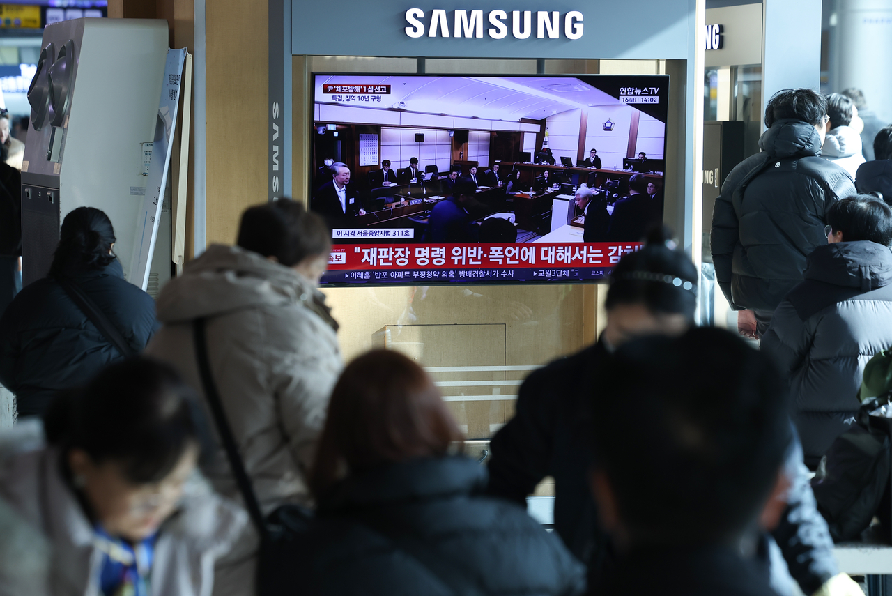 A live broadcast of the first-trial verdict hearing for former President Yoon Suk Yeol, who was indicted on charges including obstructing an arrest by the Corruption Investigation Office for High-Ranking Officials, is being aired on television at the main concourse of Seoul Station on Friday. (Yonhap)