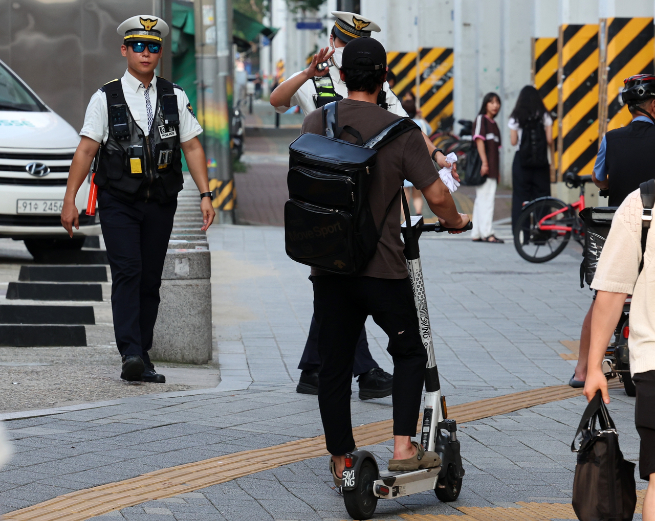 Police officers conduct on-site checks for electric scooter riders without helmets near Seongsu Station in Seongdong-gu, Seoul. (Newsis)