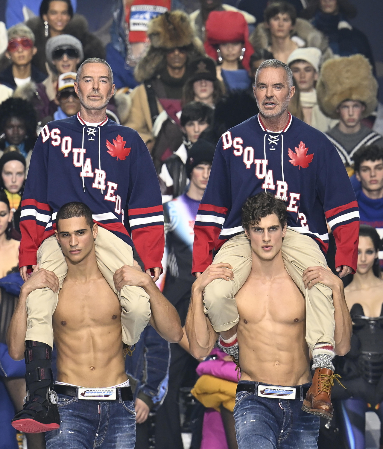 Canadian designers Dean Caten and Dan Caten, founders of Italian fashion brand Dsquared2, sit on the shoulders of models presenting their creations for the fall-winter 2026-27 Men's Collection during Milan Men's Fashion Week in Milan on Jan. 16. (EPA/Daniel Dal Zennaro)