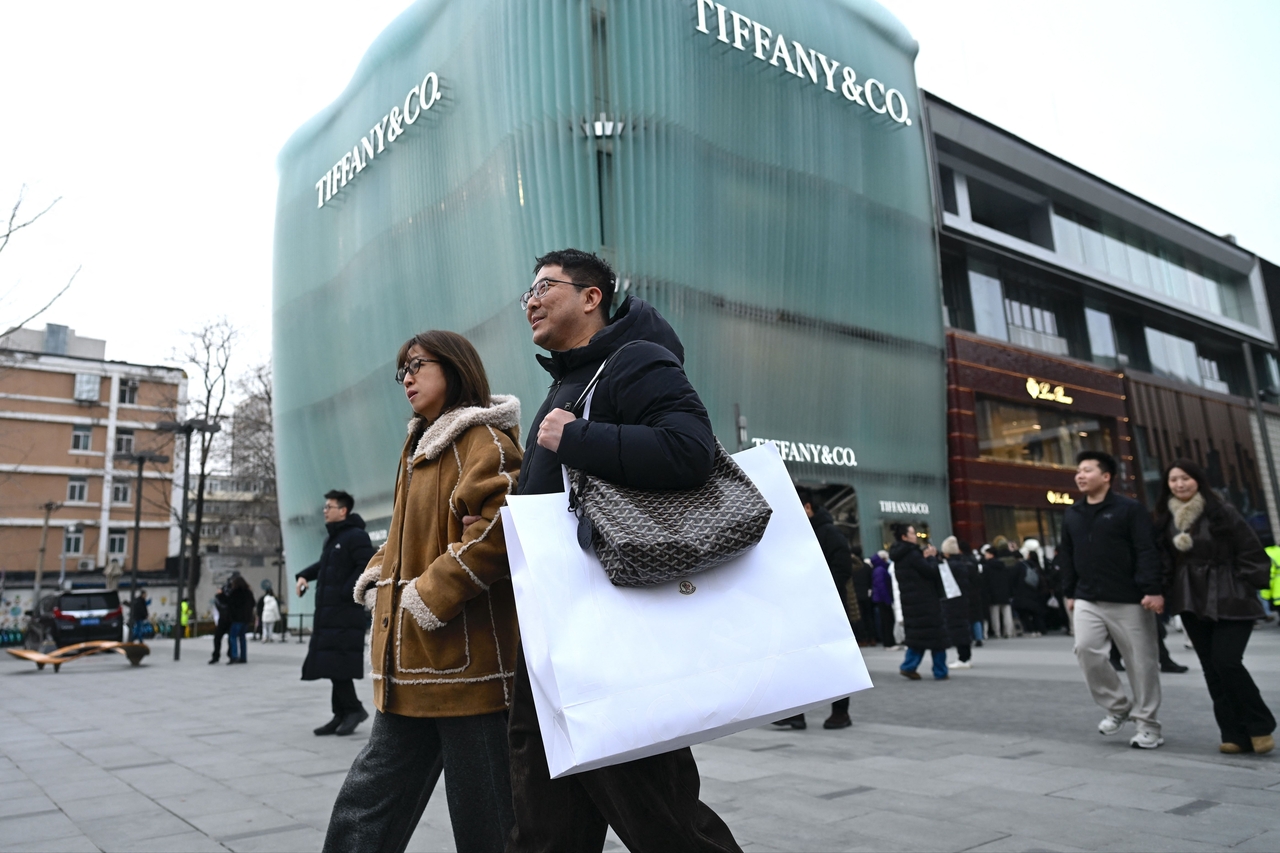 People walk out from a mall in Beijing on Sunday.   AFP-Yonhap