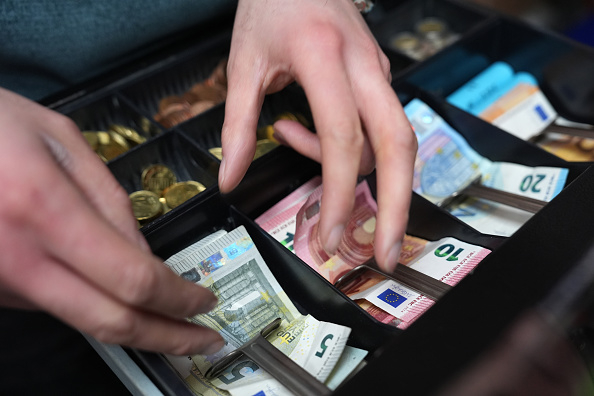 A kiosk employee receives money from a customer at a shop in Hamburg, Germany, on Jan. 5. [dpa]