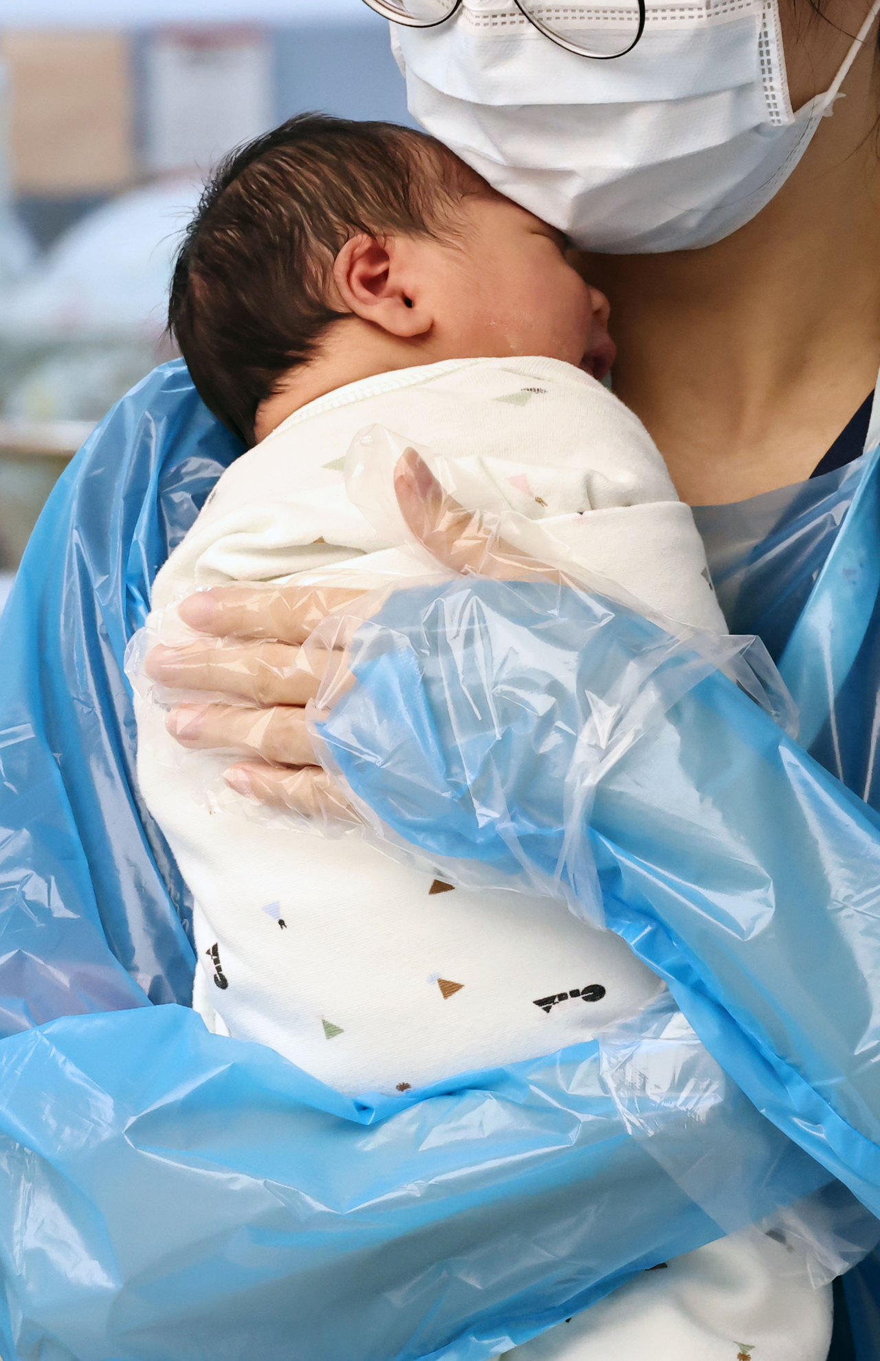 A nurse holds a newborn baby at a hospital in Goyang, Gyeonggi Province on Dec. 26. (Yonhap)