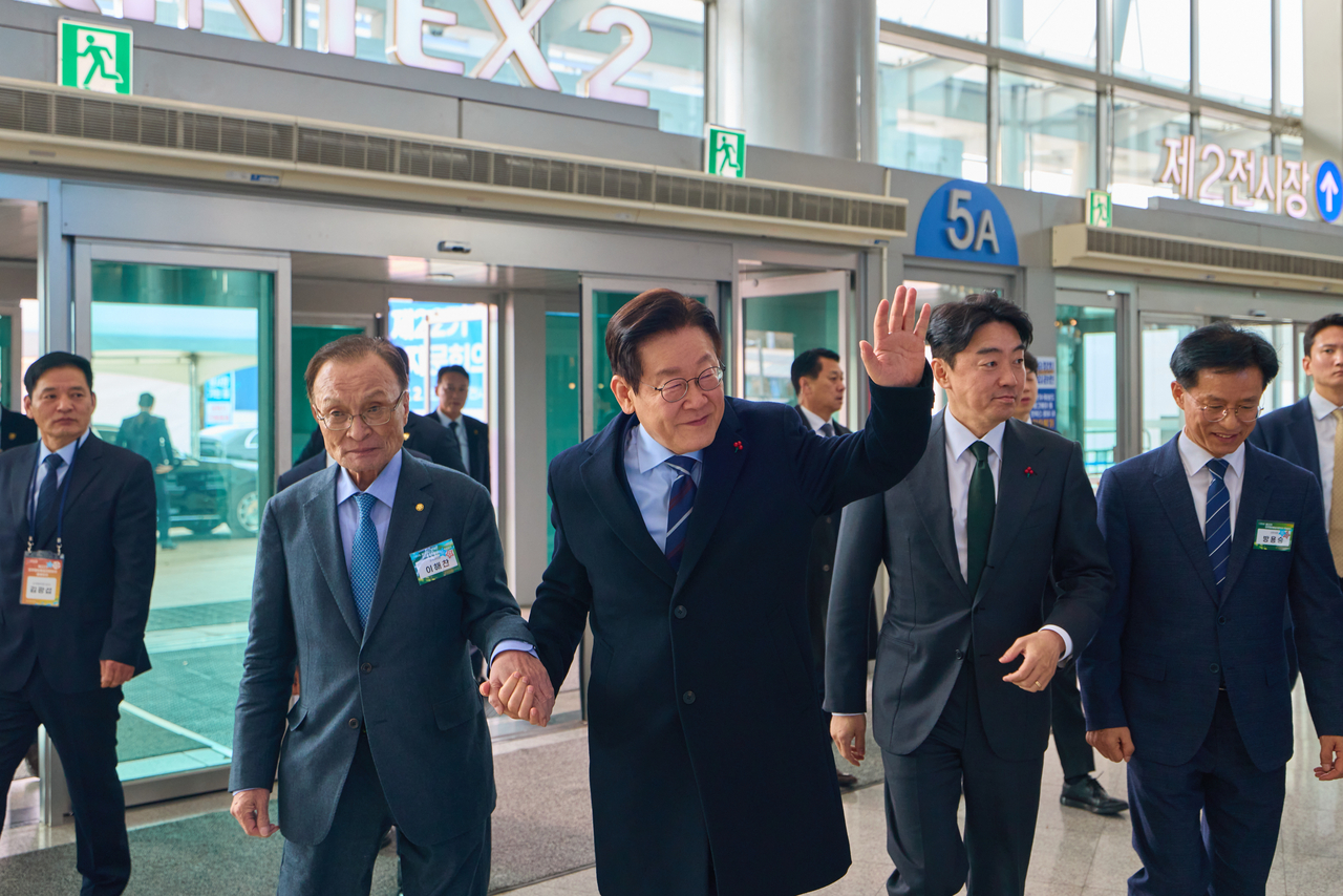 Lee Hae-chan, executive vice chair of the Peaceful Unification Advisory Council, walks hand in hand with President Lee Jae-myung toward the venue of the launch meeting of the council’s 22nd term at KINTEX in Goyang, Gyeonggi Province, on Dec. 2, 2025. (Cheong Wa Dae via Yonhap)