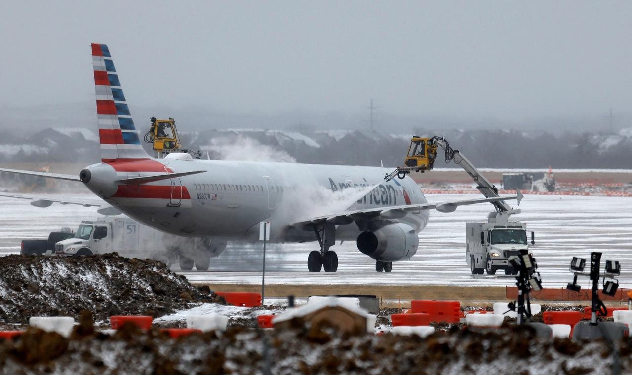 Ground crews de-ice an American Airlines jet at Dallas Fort Worth International Airport in Dallas, Texas, Saturday. (AFP-Yonhap)