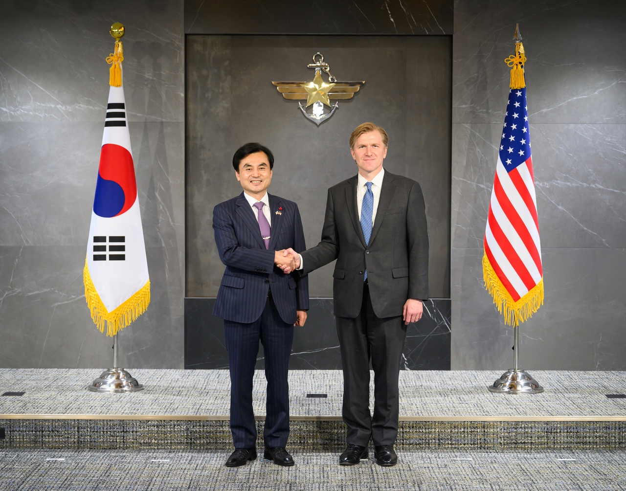 South Korean Defense Minister Ahn Gyu-back (left) shakes hands with Elbridge Colby (right), US undersecretary of defense for policy, as they pose for a photo at the Defense Ministry in Seoul on Monday. (Ministry of National Defense, Republic of Korea)