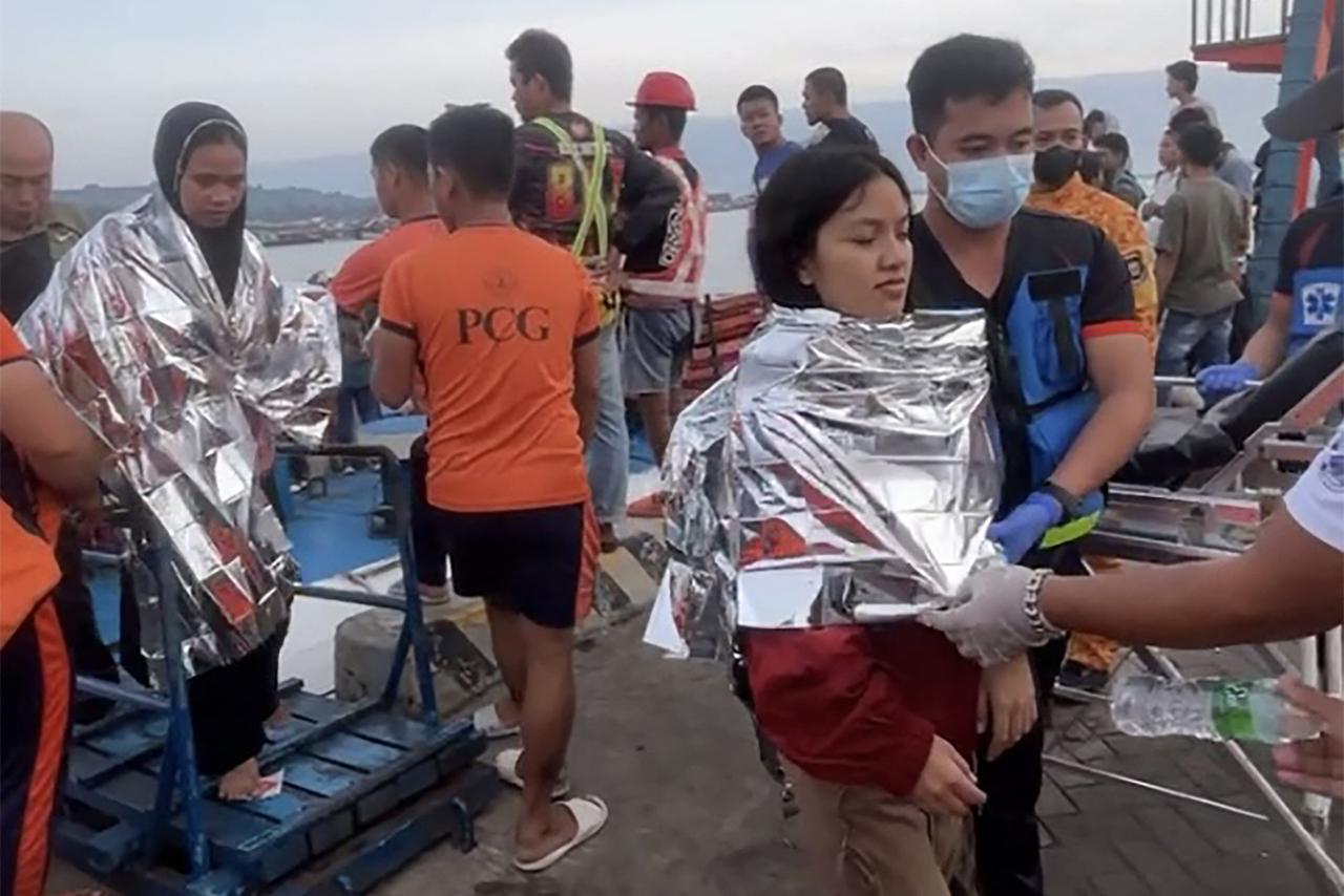 This screen grab from video footage taken on Monday shows rescuers assisting survivors of the sunken MV Trisha Kerstin 3 at a port in Isabela, Basilan province.  (AFP)