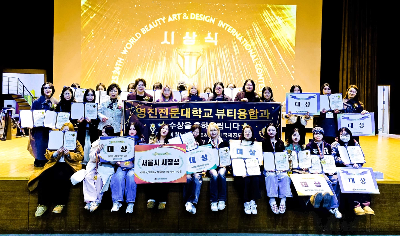 지난 24일 열린 제24회 월드뷰티아트&디자인 국제공모전 시상식에서 입상한 영진전문대 뷰티융합과 학생들이 교수진 및 대회 관계자들과 함께 기념촬영을 하고 있다.[영진전문대 제공]
