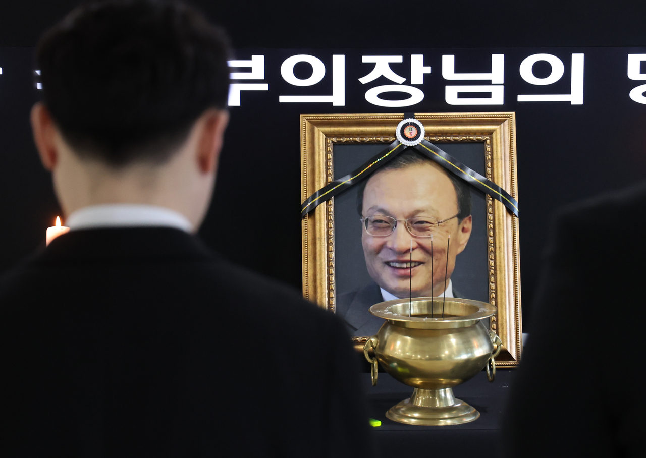 Officials observe a moment of silence after laying flowers at a memorial space for former Prime Minister Lee Hae-chan at the Presidential Advisory Council on Democratic and Peaceful Unification in Jung-gu, Seoul, Tuesday. (Yonhap)
