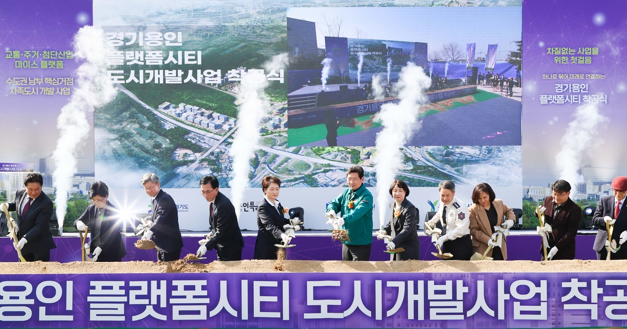 Yongin Special City Mayor Lee Sang-il (sixth from right) and Rep. Lee Eon-ju of the Democratic Party of Korea (fifth from left) shovel earth with other local officials during the groundbreaking ceremony for Yongin’s Platform City development project in Gyeonggi Province on March 11, 2025. (Yongin Special City)