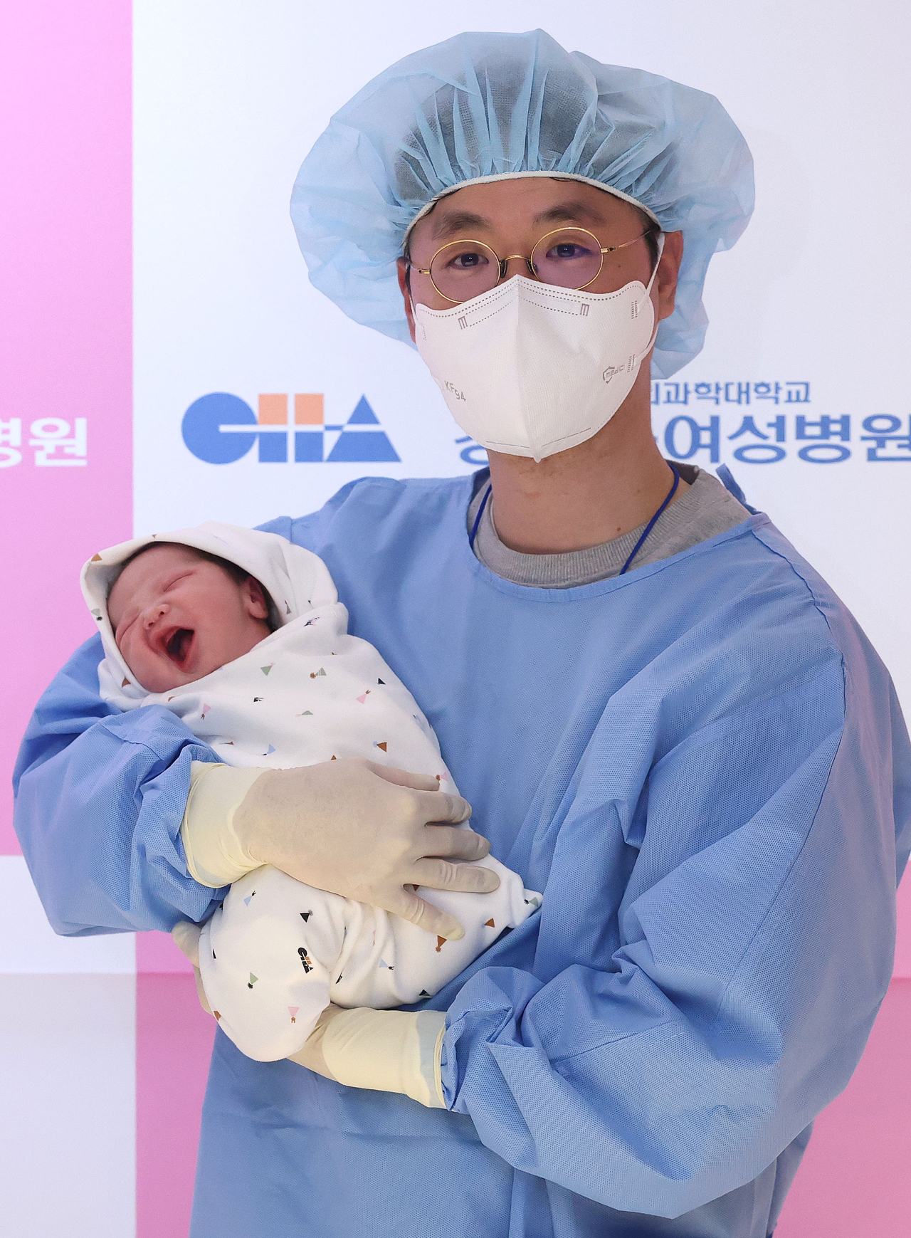 A man holds his newborn baby at the Cha Gangnam Medical Center in Seoul on Jan. 1. (Yonhap)