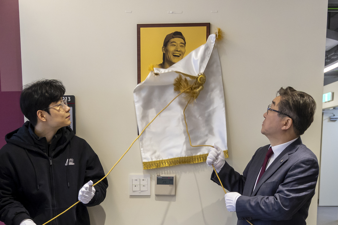 Korea University President Kim Dong-won (right) and Lee Jin-ho, a family member of the late Lee Young-chul, unveil a commemorative plaque at the student cafeteria on the university's main campus in Seoul on Tuesday. (Yonhap)