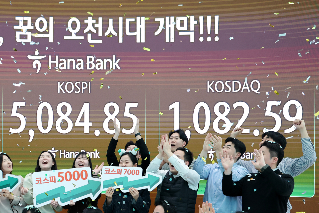 종가 기준 코스피 지수가 5000선· 코스닥이 1000선을 동시에 돌파한 지난 27일 서울 중구 하나은행 딜링룸에서 직원들이 기념 세레머니를 하고 있다. [연합]
