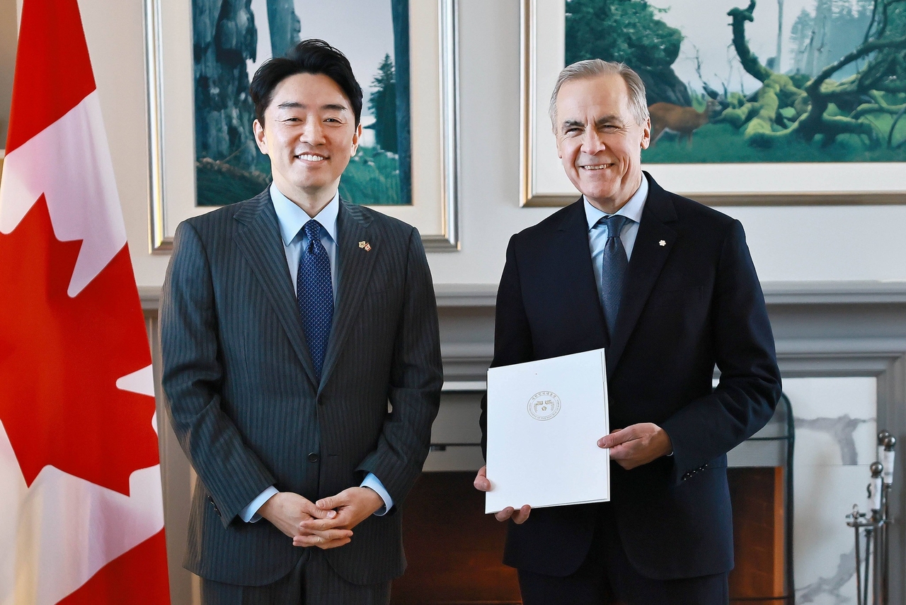 Kang Hoon-sik (left), President Lee Jae Myung's chief of staff, and Canadian Prime Minister Mark Carney pose for a photo after Kang delivered Lee's personal letter to Carney, in this photo captured from Kang's Facebook account. (Yonhap)