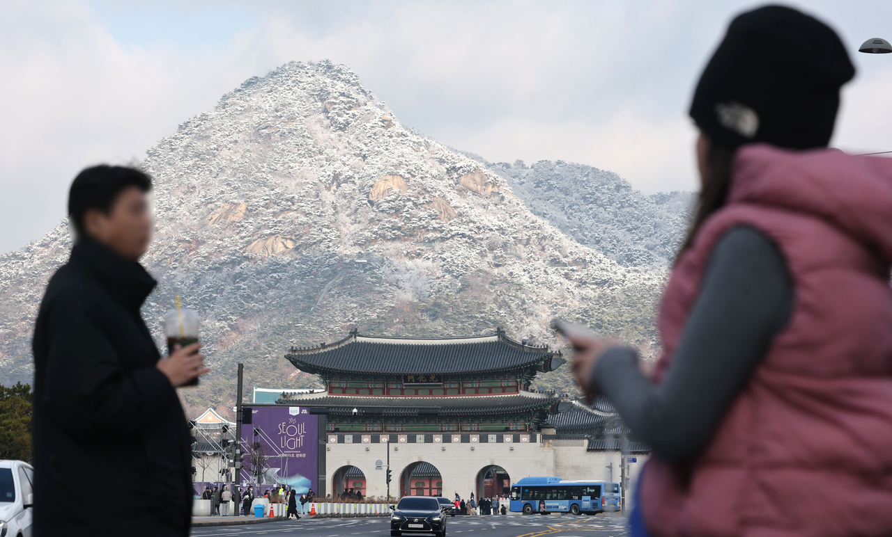 Pedestrians walk through Gwanghwamun Square in Seoul on Jan. 14. (Yonhap)