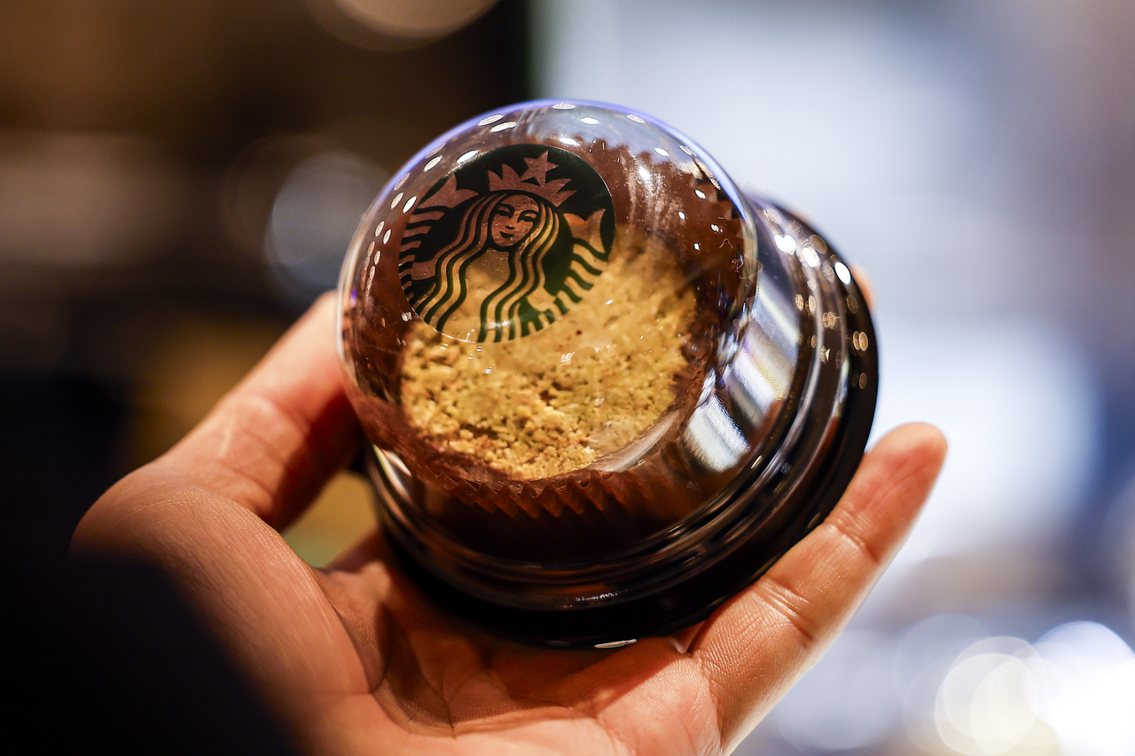 Customers at the Starbucks Hongdae Donggyo branch in Mapo-gu, Seoul, take photos after purchasing the Starbucks Dubai chewy roll. (Newsis)