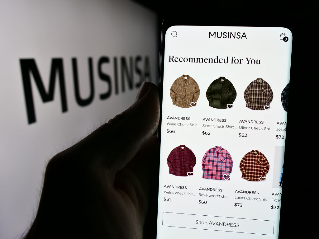 A person holds a smartphone with the webpage of Korean fashion company Musinsa (Getty Images).