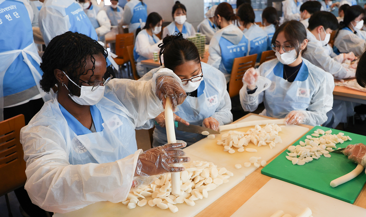 International students at Yeungnam University prepare meal kits of tteokguk, a traditional Korean rice cake soup, during a volunteer activity on campus in Gyeongsan, North Gyeongsang Province, Jan. 5. (Yonhap)