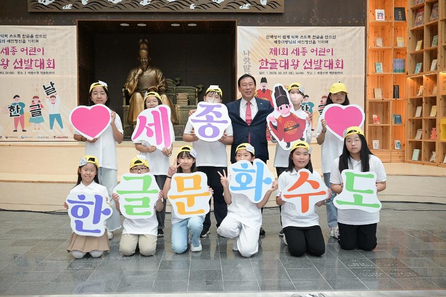 Sejong Mayor Choi Min-ho (third from right, back row) poses with children participating in a Korean language contest held in 2023, with panels reading “Hangeul Culture Capital Sejong.” (Sejong City)