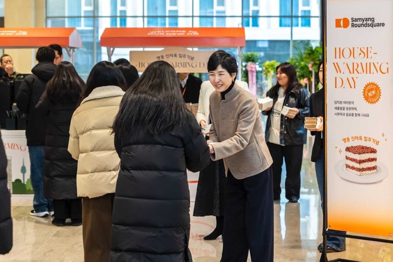 Kim Jung-soo, vice chair of Samyang RoundSquare, hands out snacks to employees at the House Warming Day event held at the company’s new headquarters in Myeong-dong, Seoul, Friday. (Samyang Round Square)