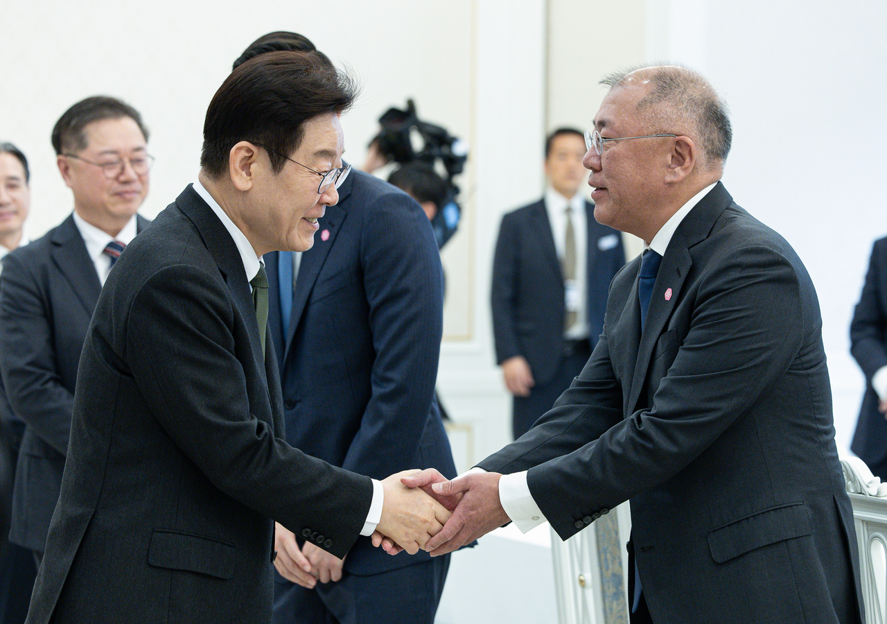 Lee Jae Myung greets Hyundai Motor Group Executive Chair Chung Euisun as he enters a corporate meeting on expanding youth employment and regional investment at Cheong Wa Dae on Wednesday. (Yonhap)