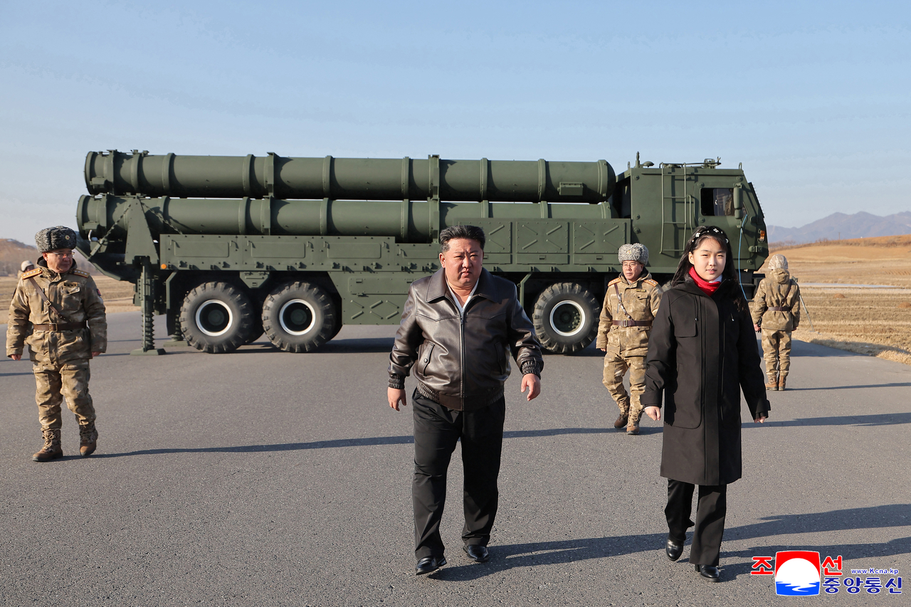 North Korean leader Kim Jong-un (center), acㅁcompanied by his daughter Ju-ae, inspects a test-firing of an upgraded large-caliber multiple rocket launcher system to assess its effectiveness at an unspecified location on Jan. 27, 2026, in this photo released by North Korea's Korean Central News Agency the next day. South Korea's military has said it detected multiple short-range ballistic missiles launched from north of Pyongyang toward the East Sea. (Yonhap)
