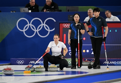 Kim Seon-yeong (C) and Jeong Yeong-seok (R) of South Korea watch as Julie Zelingrova of the Czech Republic prepares for a shot during their teams' round-robin match in the mixed doubles curling tournament of the Winter Olympics at Cortina Curling Olympic Stadium in Cortina d'Ampezzo, Italy, on Saturday. (Reuters-Yonhap)