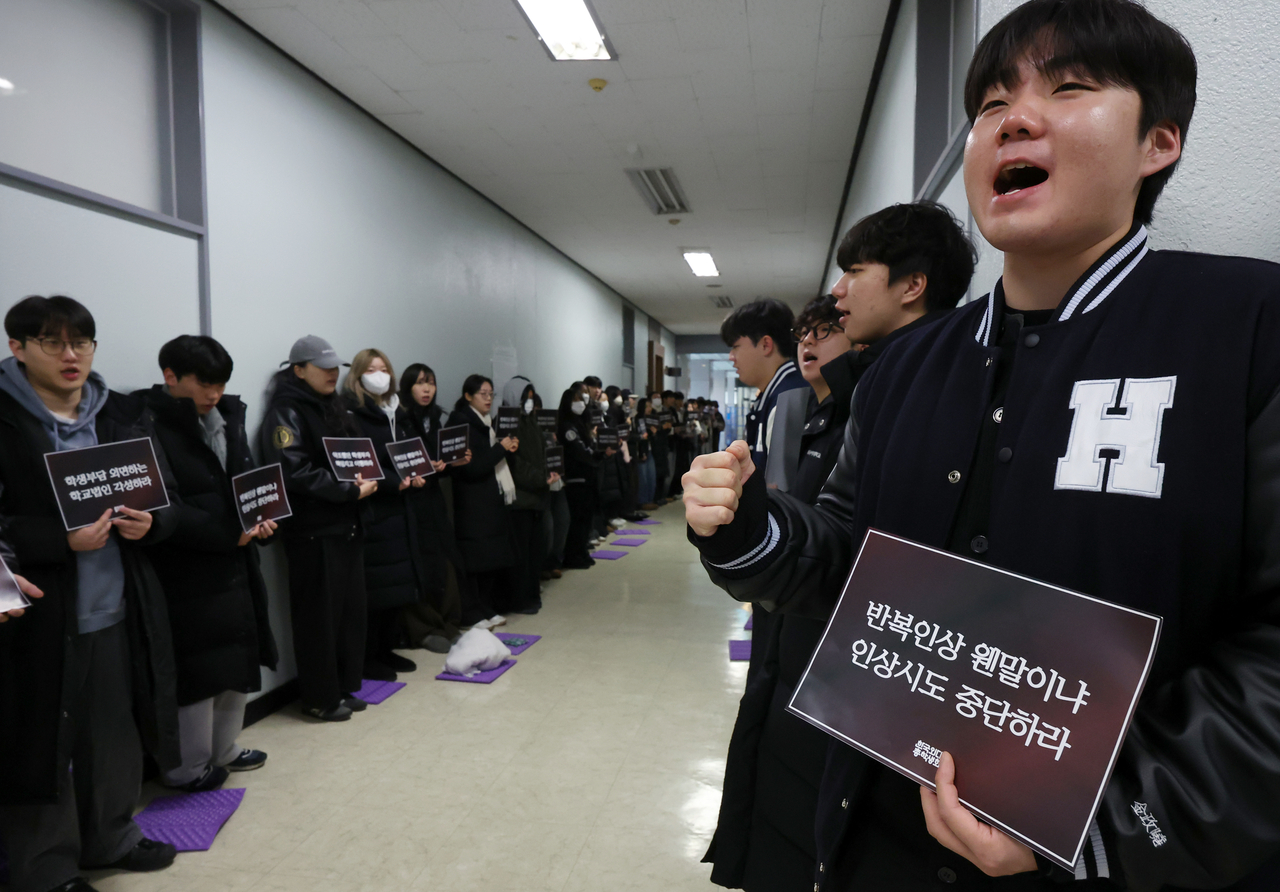 Students at Hankuk University of Foreign Studies on Jan. 21 hold signs that read, "What do you mean repeated (tuition) increases? Stop the hike attempts," at the university's Seoul campus to protest the university's decision to increase tuition by 3.19 percent. (Newsis)