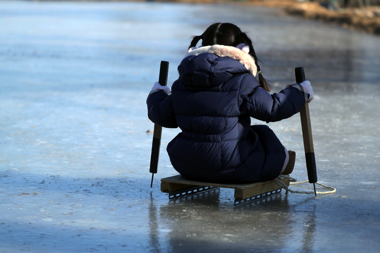 A child tries ice sledding in Sokcho, Gangwon Province, on Jan. 27. (Yonhap)