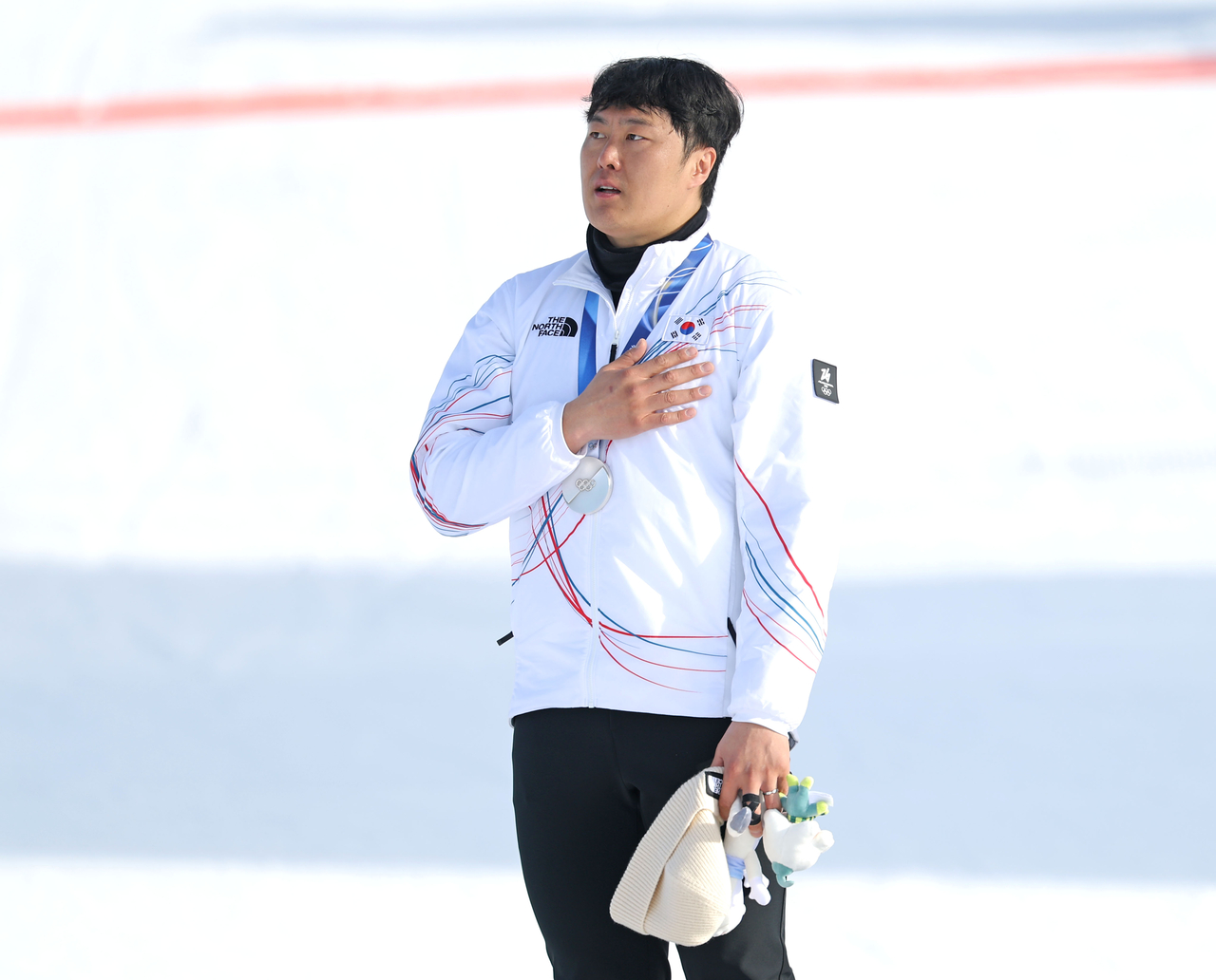 South Korea's national anthem is played after snowboarder Kim Sang-kyum  won silver in the men’s parallel giant slalom event at the Milano Cortina Winter Games on Sunday. (Yonhap)
