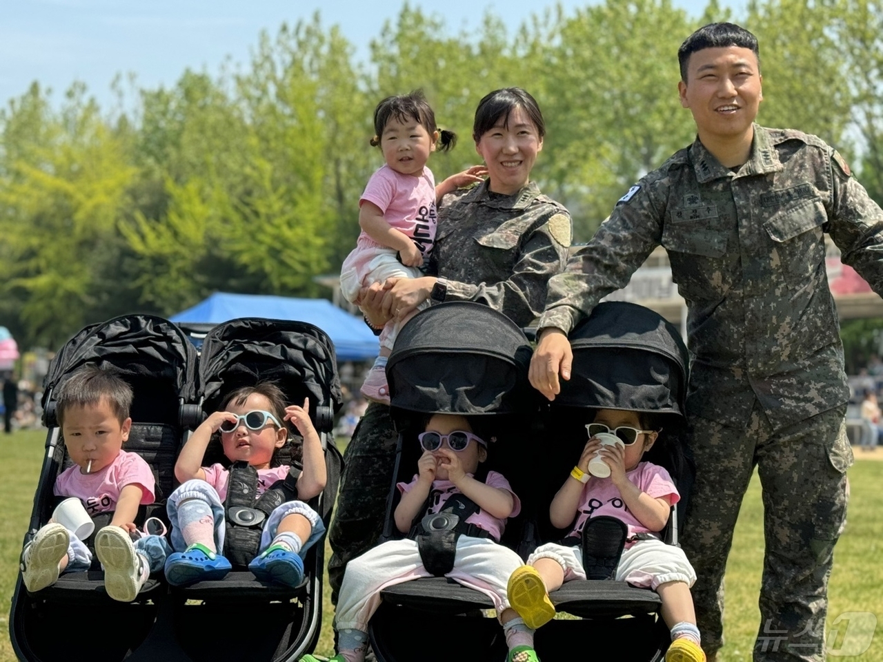 Army Maj. Seo Hye-jung (left) and Army Capt. Kim Jin-su pose for a photo with their quintuplets. (South Korean Army)