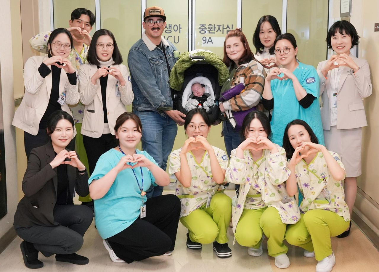Stetson (center), his parents and Seoul St. Mary's Hospital staff pose for a photo on Friday to celebrate his discharge after being born extremely premature. (Seoul St. Mary's Hospital)