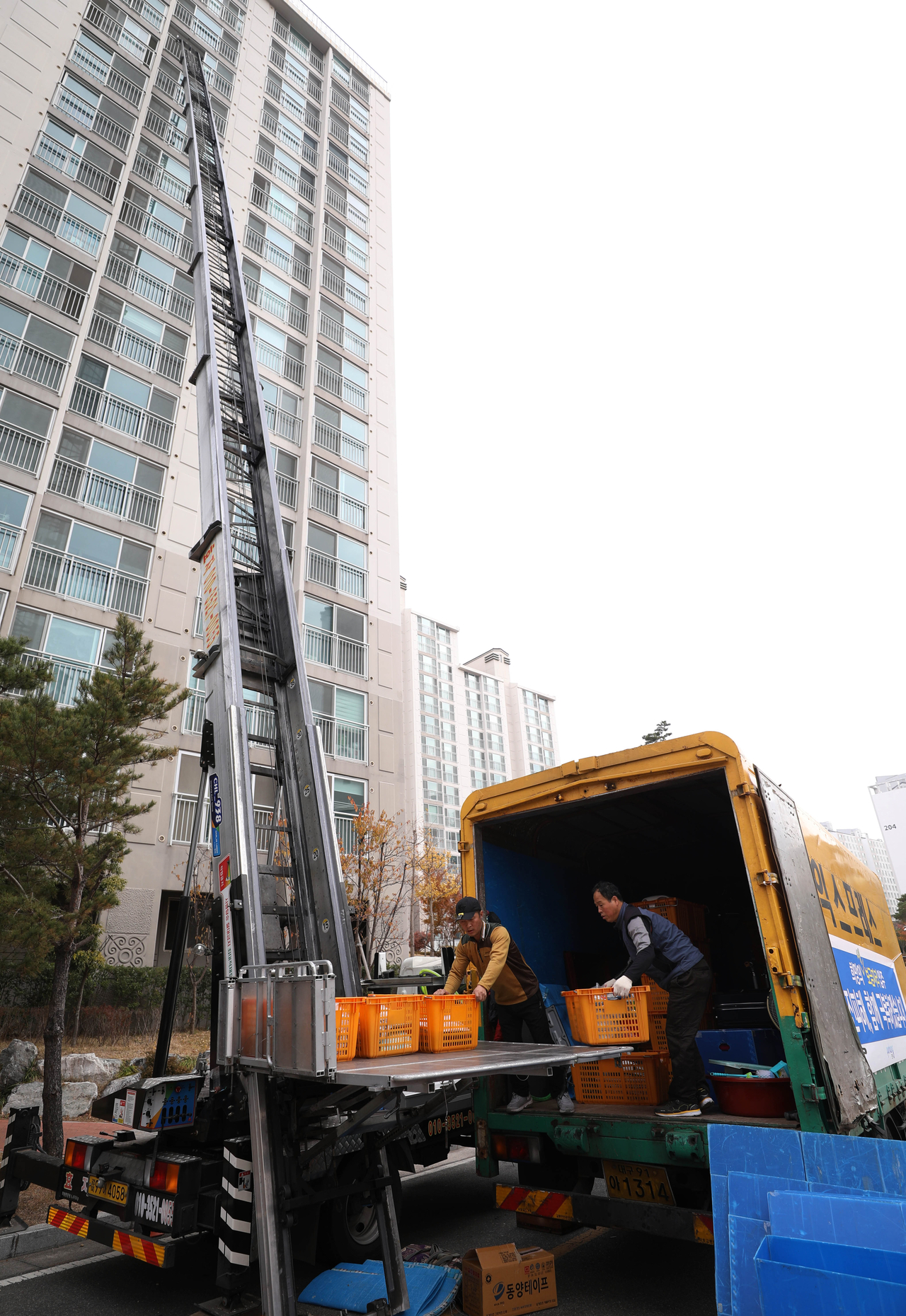 Moving company workers transfer household belongings using a ladder truck at an apartment complex in Buk-gu, Pohang, North Gyeongsang Province. (Newsis)
