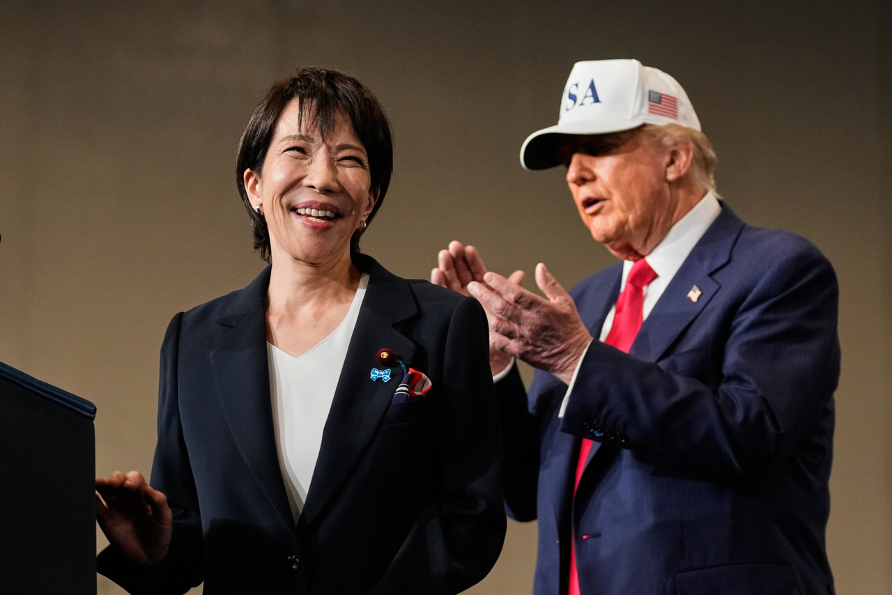 Japanese Prime Minister Sanae Takaichi, with US President Donald Trump, reacts as she was speaking to members of the military aboard the USS George Washington, an aircraft carrier docked at an American naval base, in Yokosuka, on Oct. 28. (File Photo - AP)