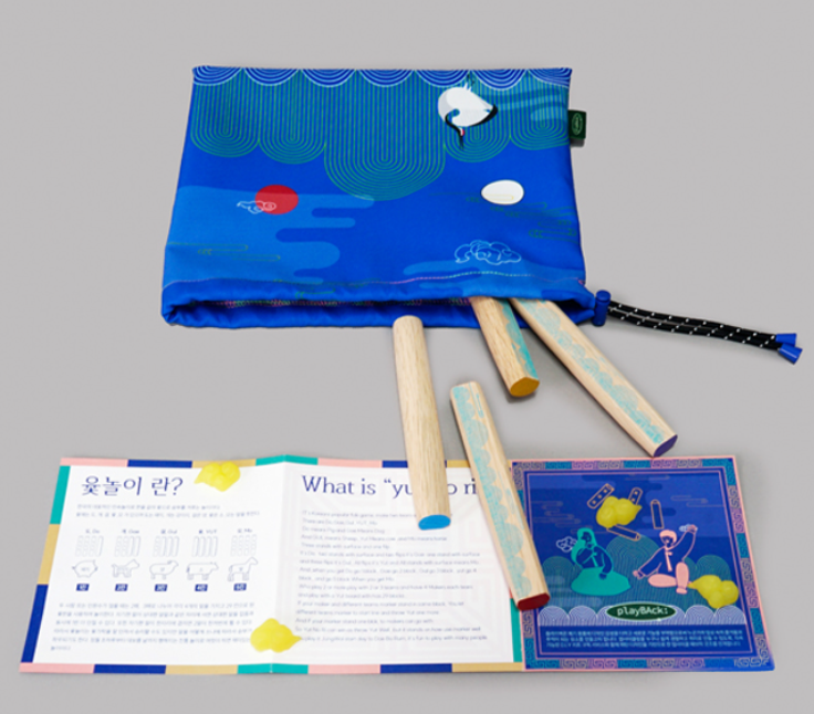A traditional Korean yutnori game set featuring four curved wooden yut sticks colorful mal game tokens and a traditional Korean game board displayed at the National Museum of Korea